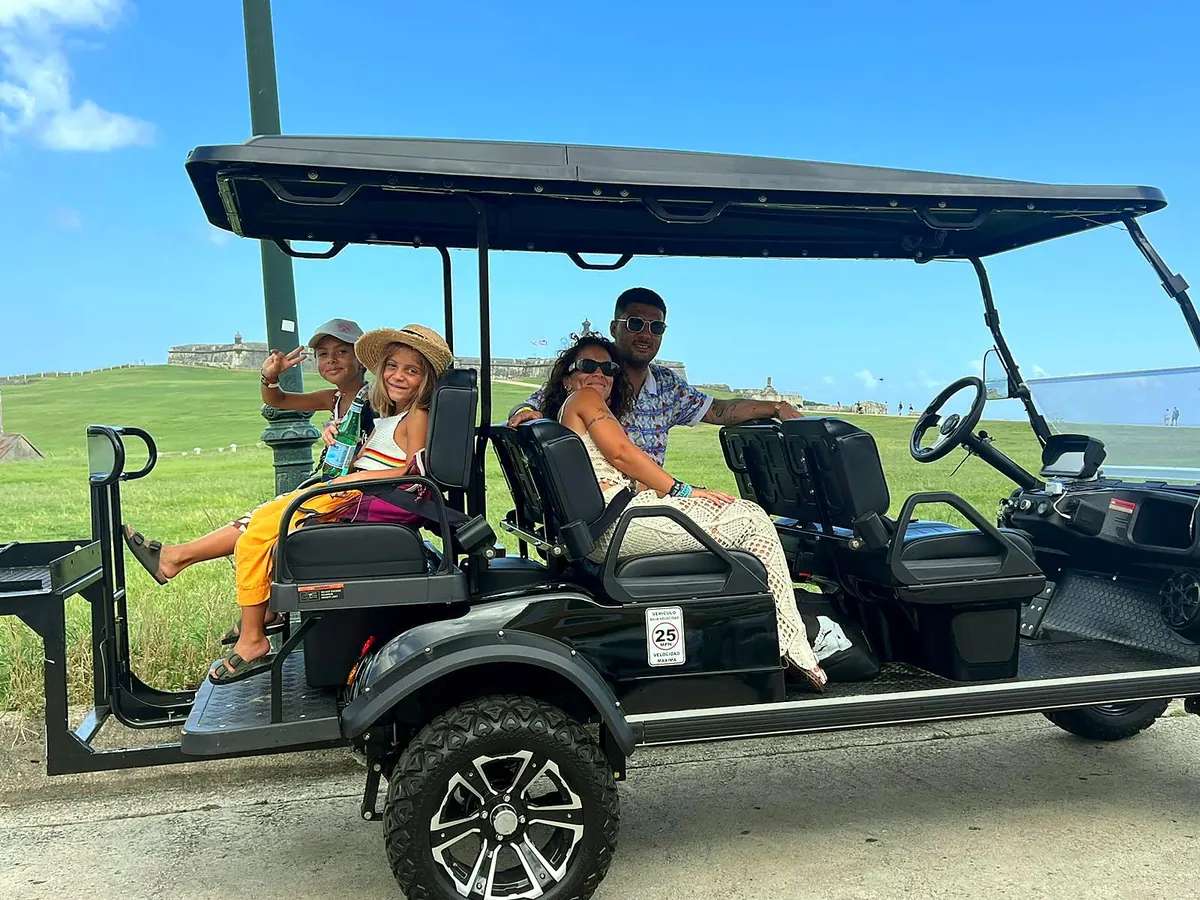 A family waving from their Ports to Forts cart on the El Morro grounds in Old San Juan
