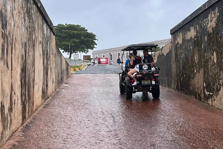 A cart with riders passing between the old city walls