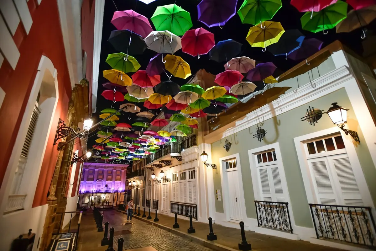 Colorful umbrellas strung over an Old San Juan street at night